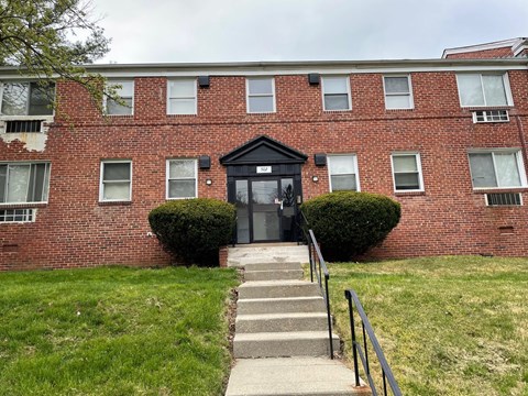 the front of a brick building with stairs in front of it
