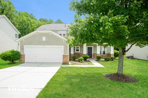 a white house with a tree in front of it