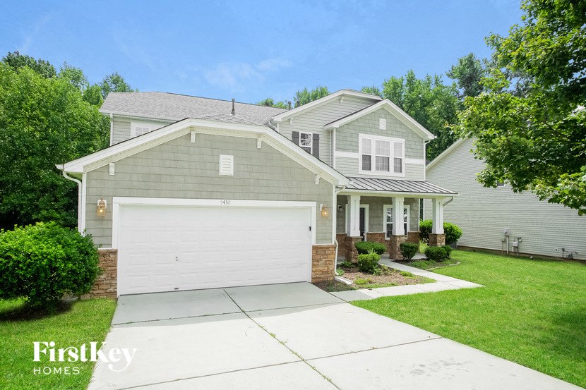 a gray house with a white garage door on a driveway