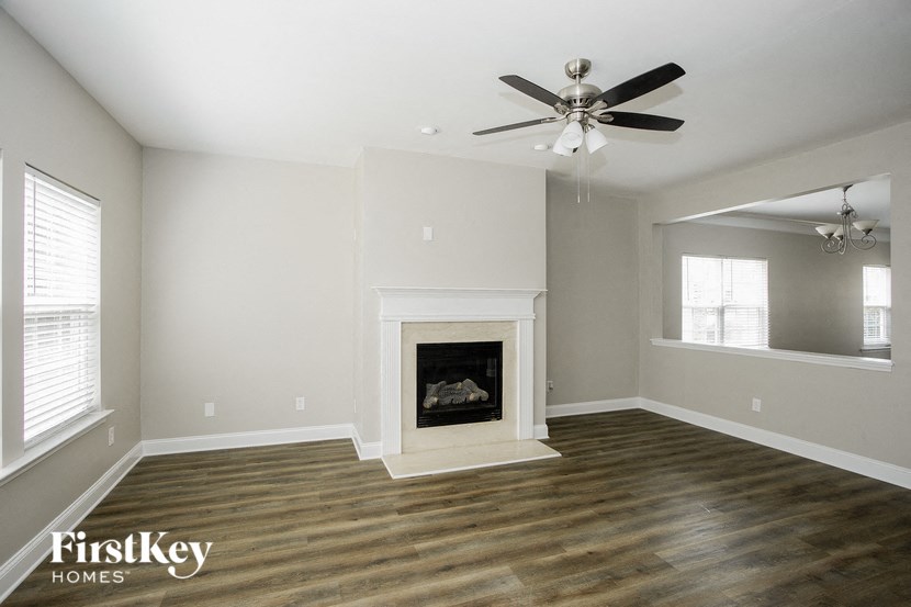 a living room with a fireplace and a ceiling fan
