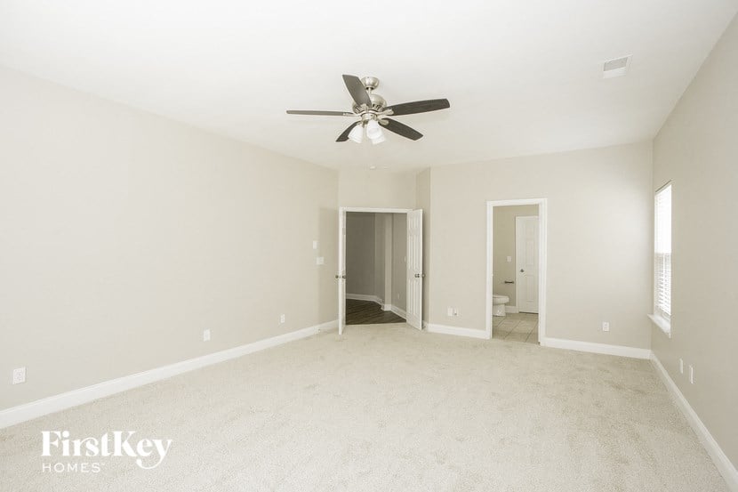 a clean and empty living room with a ceiling fan