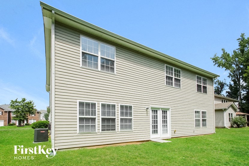 a white house with white siding on a green lawn