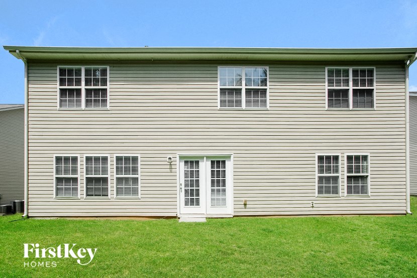 a white house with white siding and a green lawn