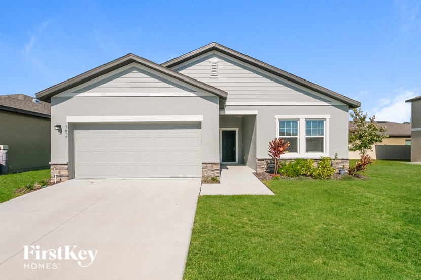 A house with a garage and a driveway in front of it.