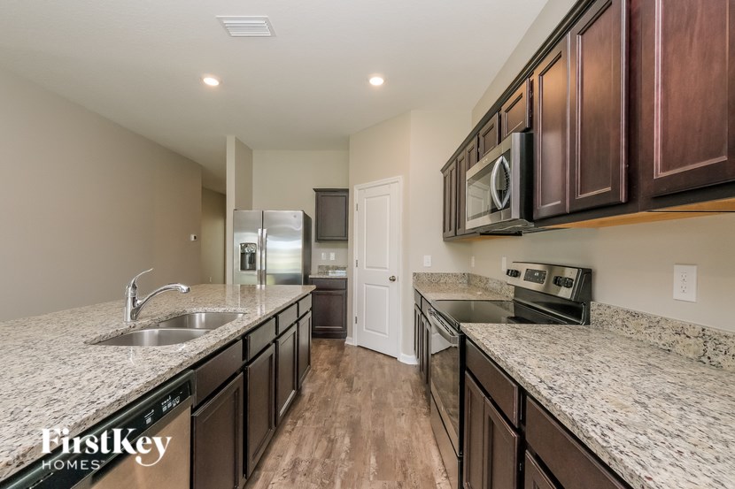 A kitchen with dark wood cabinets and granite countertops.
