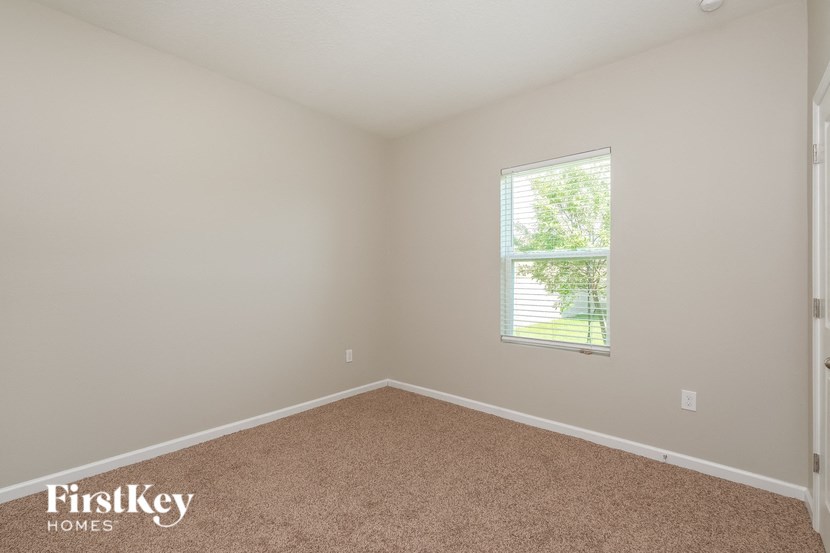 A room with a carpeted floor and a window letting in natural light.