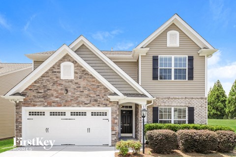 a tan brick house with a white garage door