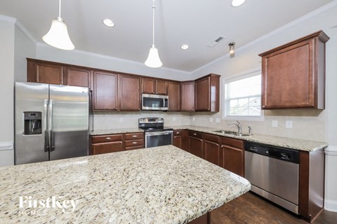 a kitchen with wooden cabinets and granite counter tops and stainless steel appliances