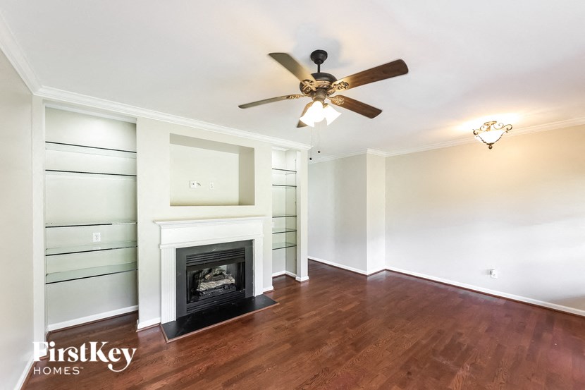 a living room with a fireplace and a ceiling fan