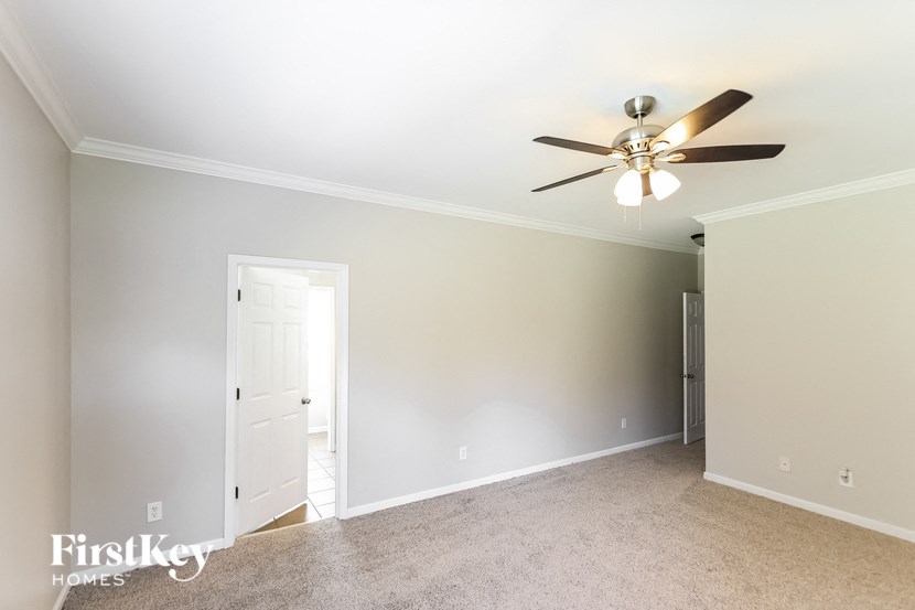 a bedroom with a ceiling fan and a door to a closet