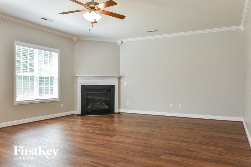 a living room with a fireplace and a ceiling fan
