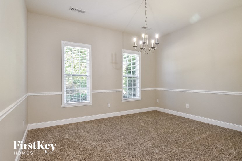 a empty room with two windows and a chandelier