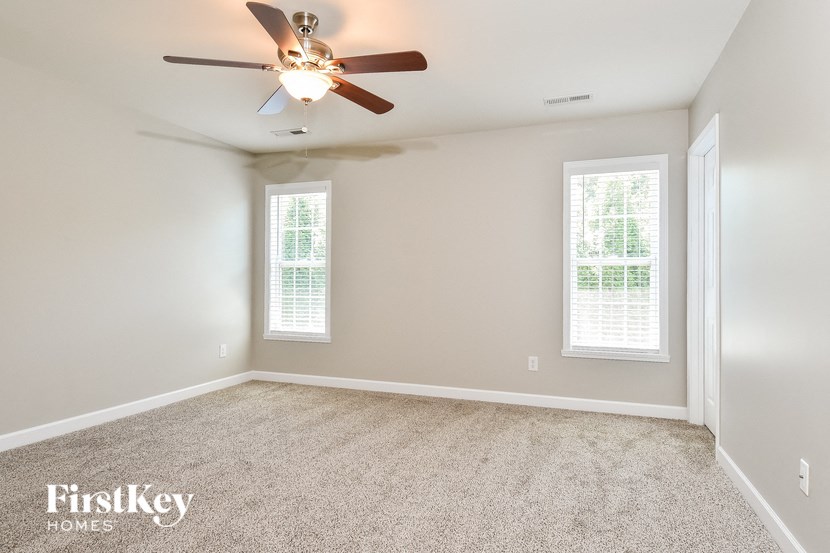 an empty room with a ceiling fan and window