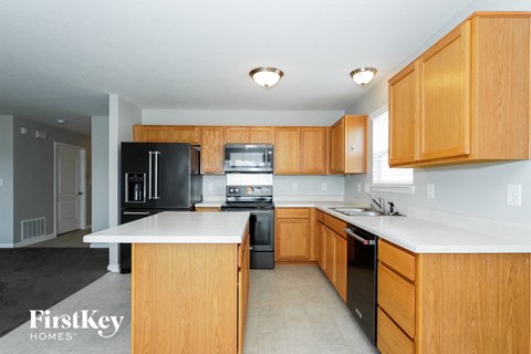 a large kitchen with wooden cabinets and black appliances