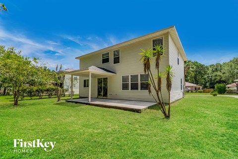 A house with a lawn and trees in front of it.