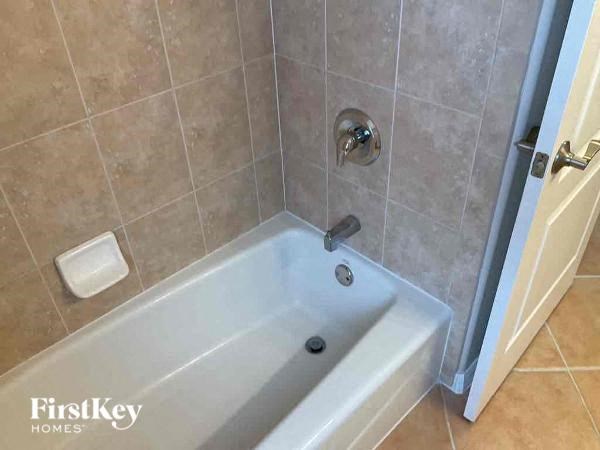 a white bath tub in a tiled bathroom