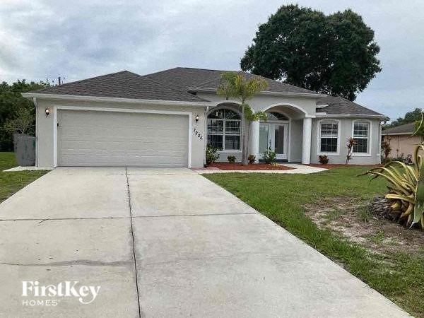 a white house with a driveway and a garage door