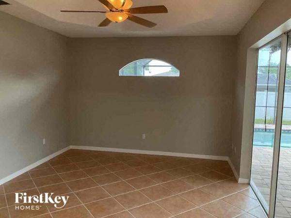 an empty room with a ceiling fan and a window