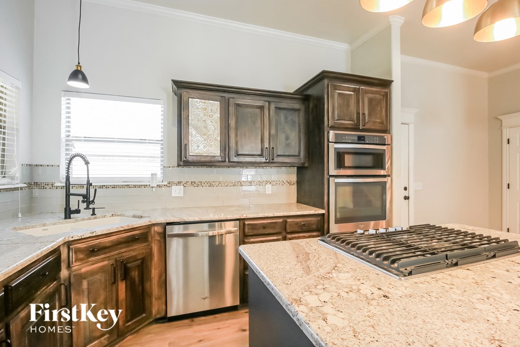 A kitchen with wooden cabinets and a stainless steel sink.