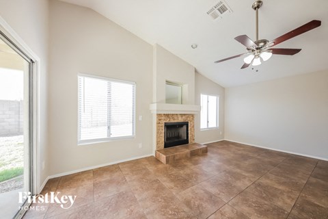 a living room with a fireplace and a ceiling fan