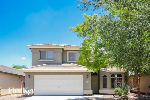 a house with a white garage door and a tree