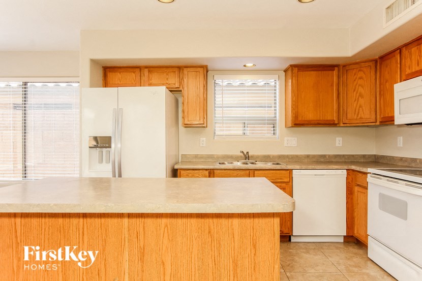 a kitchen with white appliances and wooden cabinets
