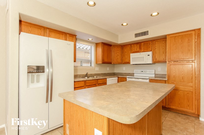 a kitchen with a white counter top and a refrigerator