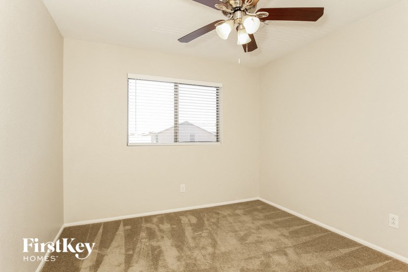 a bedroom with a ceiling fan and a window