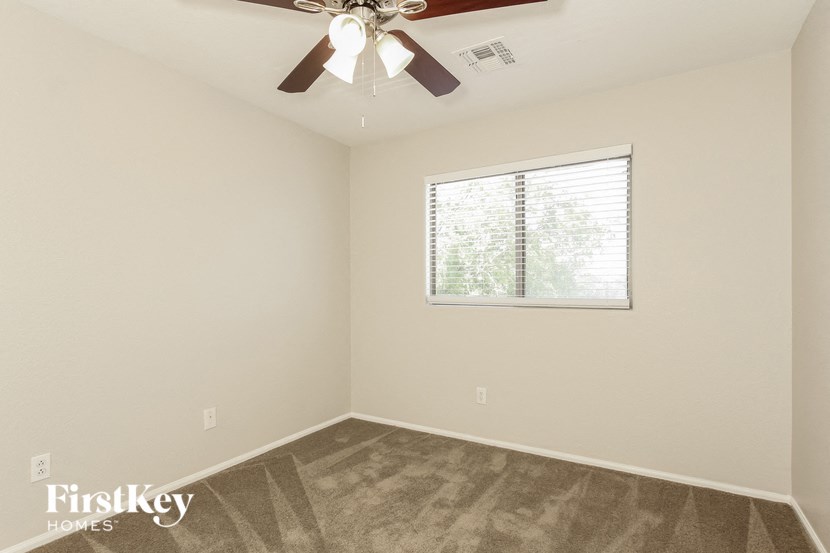 a bedroom with a ceiling fan and a window