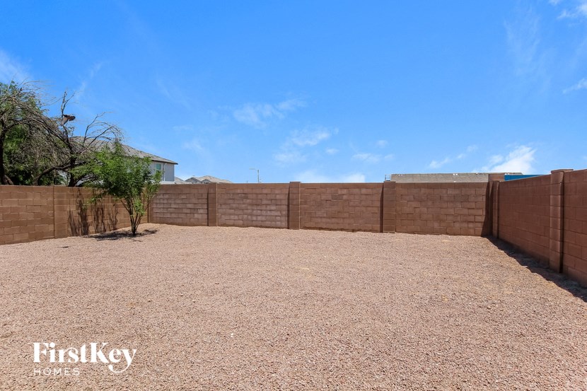 a backyard with a fence and a blue sky