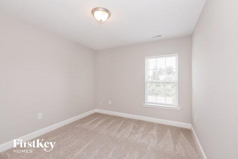 a bedroom with a carpeted floor and a window