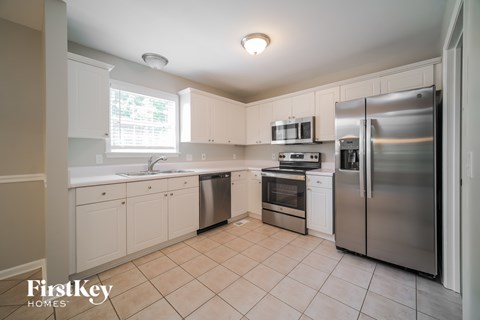 A kitchen with white cabinets and a stainless steel refrigerator.