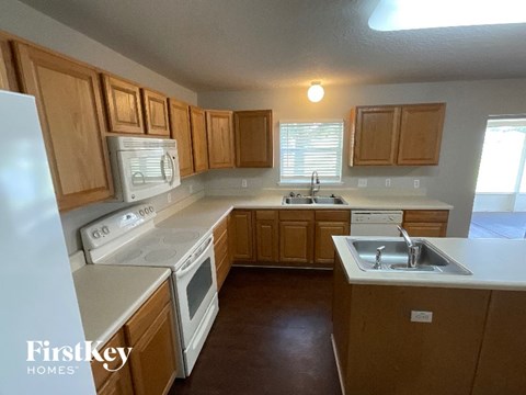 A kitchen with wooden cabinets and white appliances.