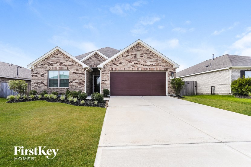 A house with a garage door is for sale by FirstKey Homes.