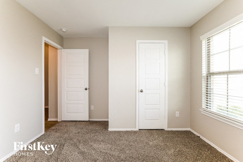 A room with two white doors and a carpeted floor.