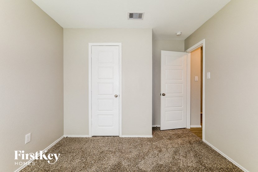 A room with two white doors and a carpeted floor.