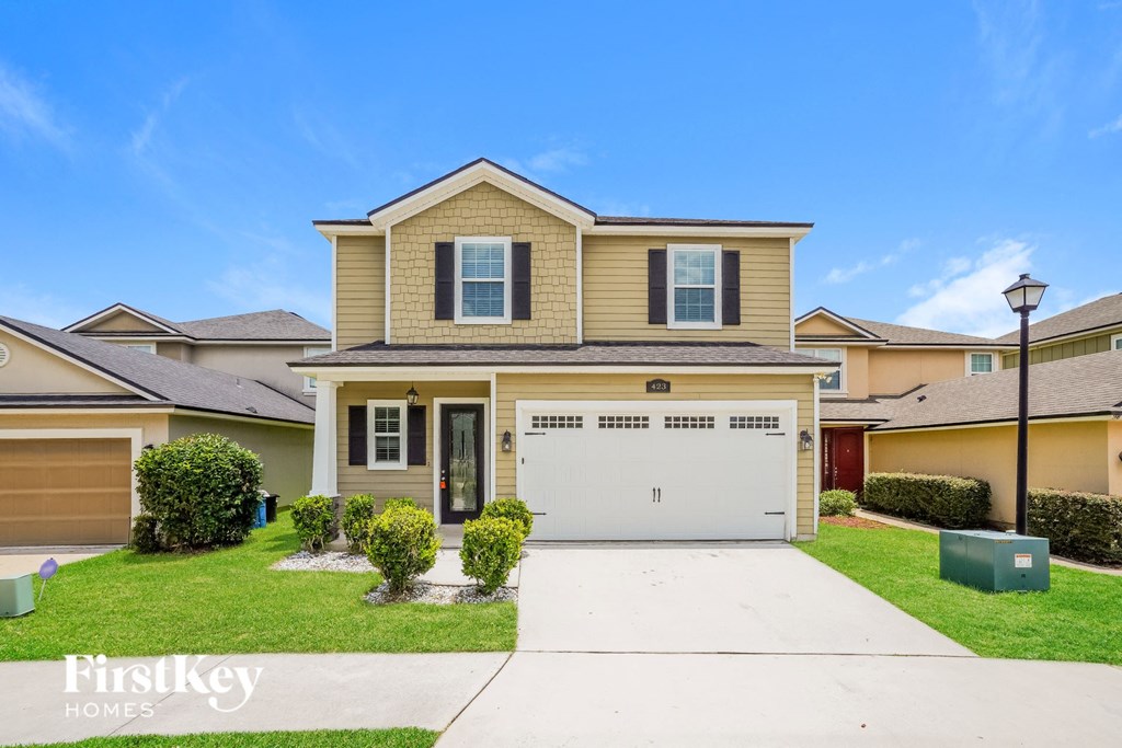 a beige and tan house with a white garage door