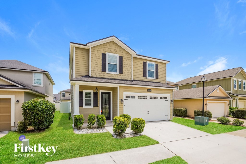 a beige and tan house with a garage and lawn