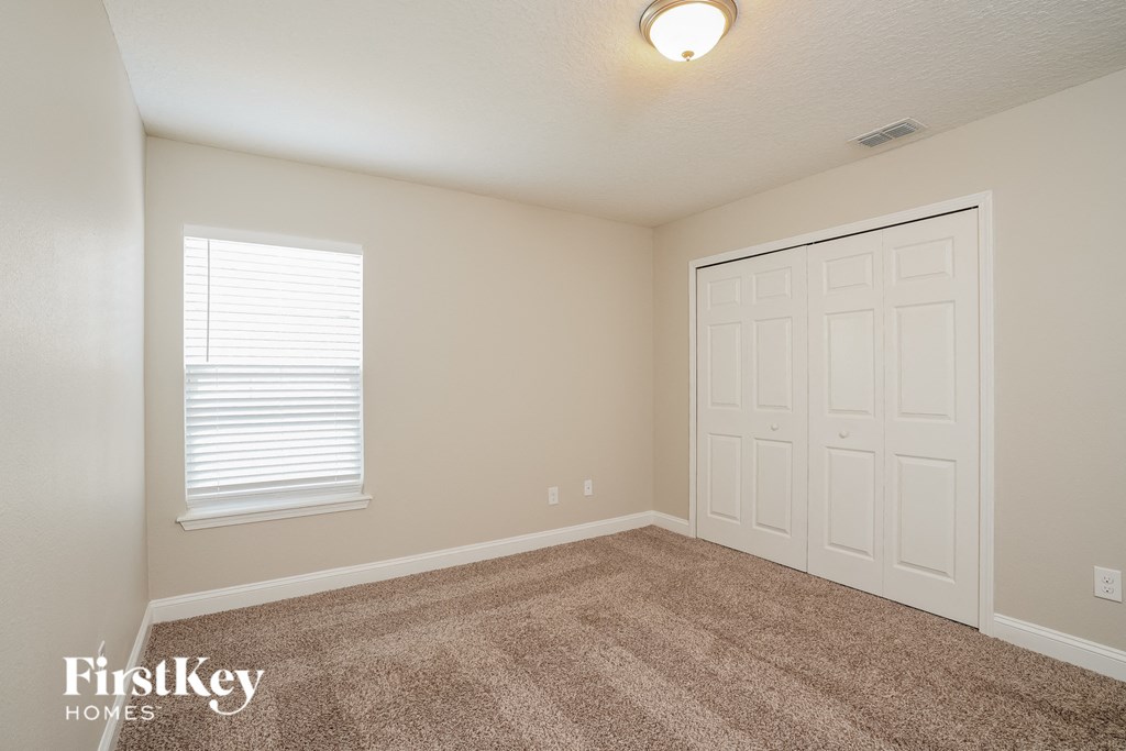 a bedroom with a carpeted floor and a white door