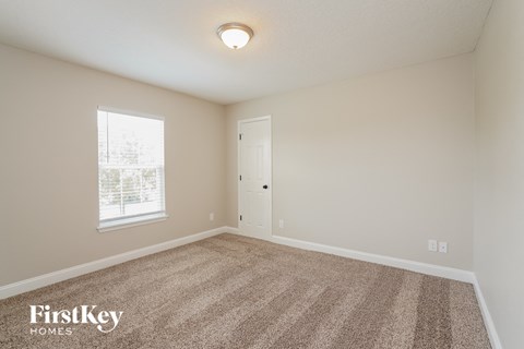 a spacious living room with carpet and a window