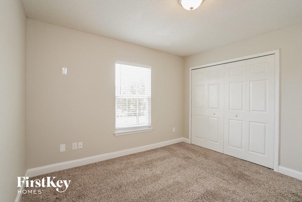 a bedroom with a carpeted floor and a white door