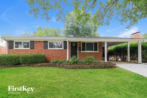 a small brick house with a lawn in front of it