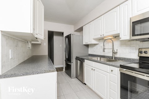 a kitchen with white cabinets and stainless steel appliances
