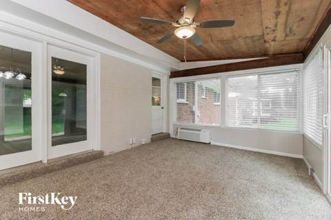a living room with a ceiling fan and a large window
