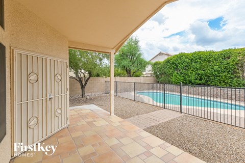 A patio with a pool and a fence.