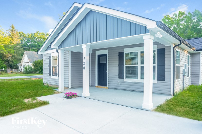 the front of a blue house with a concrete driveway