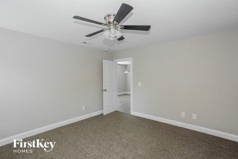a living room with a ceiling fan and carpet