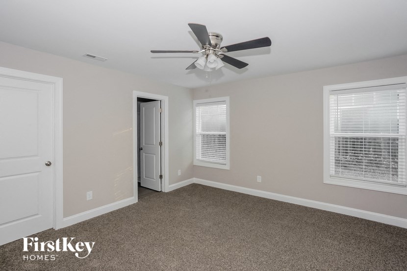 a bedroom with a ceiling fan and a door to a closet