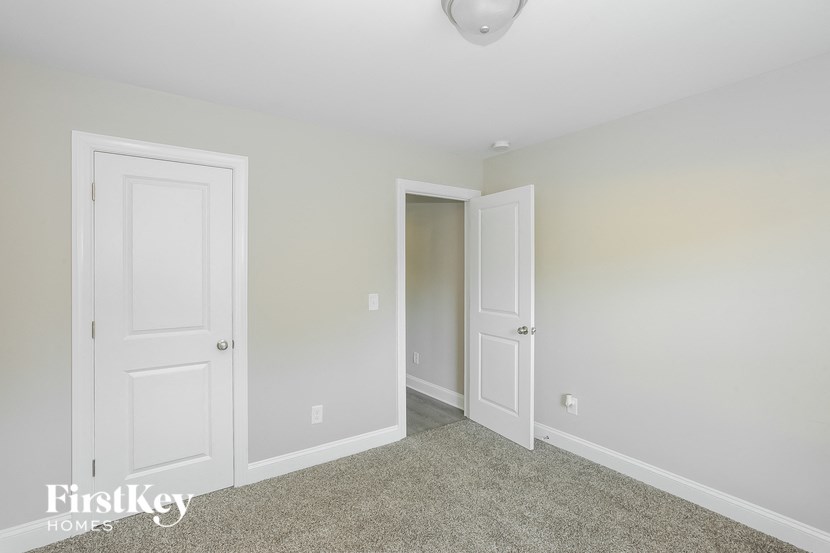 a bedroom with two doors and a door to a closet