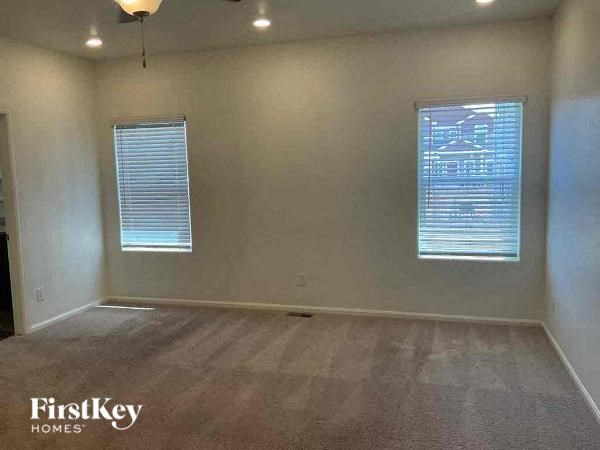 an empty living room with two windows in it